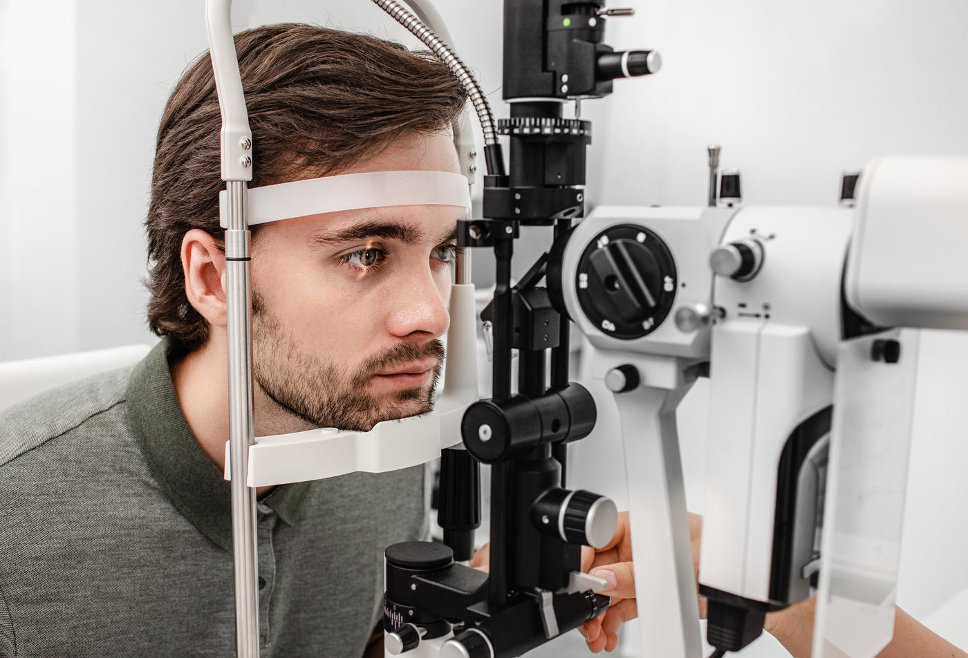 Adult man getting an eye exam at ophthalmology clinic. Checking retina of a male eye close-up